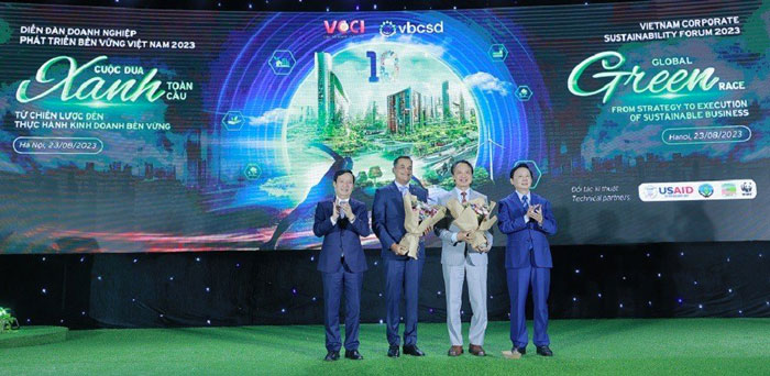 Phó Thủ tướng Trần Hồng Hà (phải, ngoài cùng) trao tặng hoa cho Chủ tịch VBCSD Nguyễn Quang Vinh (thứ 2, từ phải sang) và đồng Chủ tịch VBCSD Binu Jacob (thứ 3, từ phải sang) để ghi nhận chặng đường 10 năm tổ chức diễn đàn